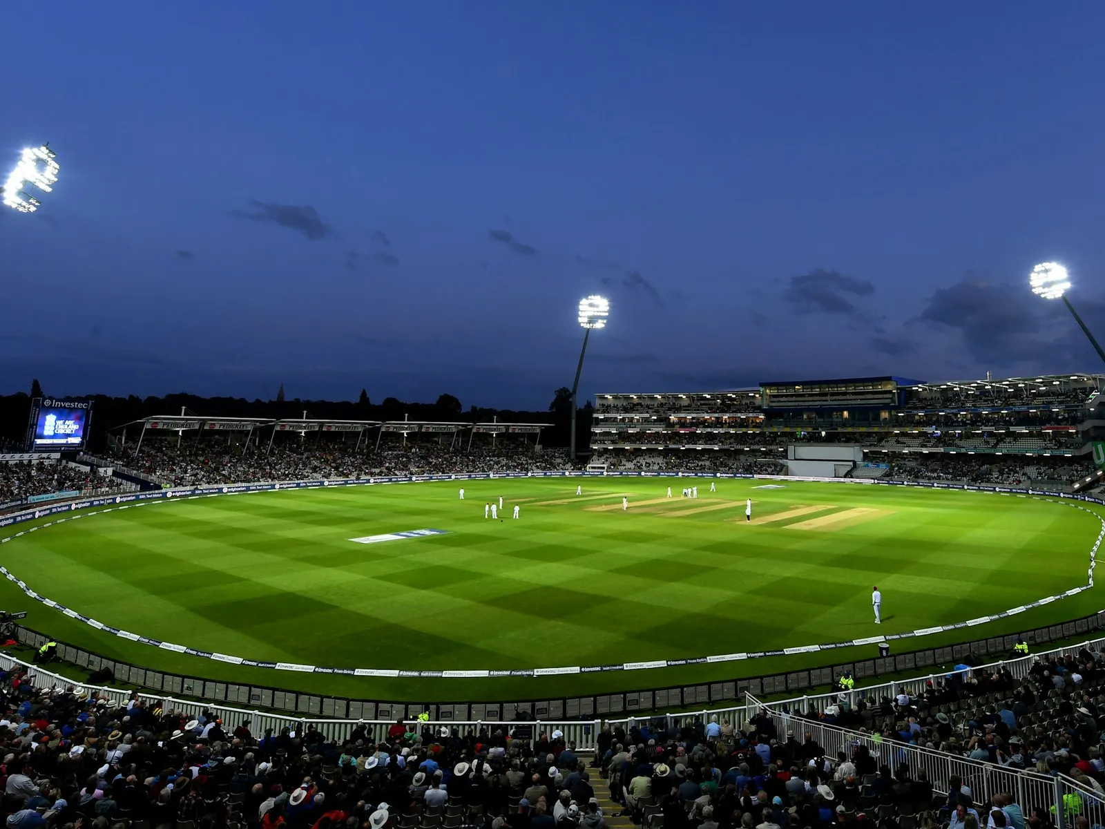 Floodlights over a packed cricket stadium at night