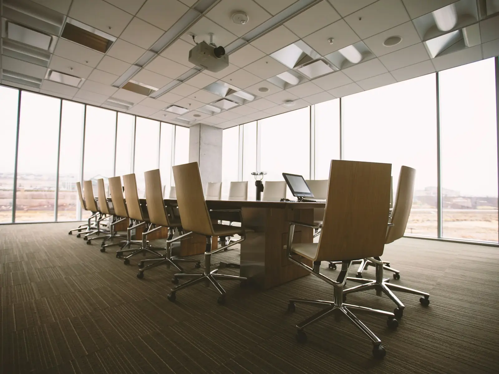 An empty boardroom with a long table and leather chairs